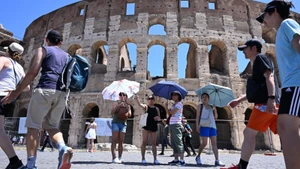 Khách du lịch che ô tránh nắng nóng khi tham quan Đấu trường La Mã ở Rome, Italia ngày 12/7/2024. (Ảnh: THX/TTXVN)