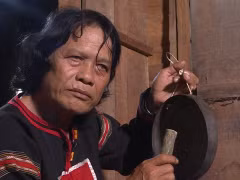 Nghệ nhân Nay Phai đang thử độ ngân khi chỉnh chiêng. (Ảnh: NX)