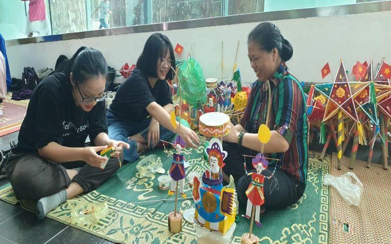 Nghệ nhân Nguyễn Thị Tuyến đang hướng dẫn cách làm đồ chơi trung thu cho du khách.
