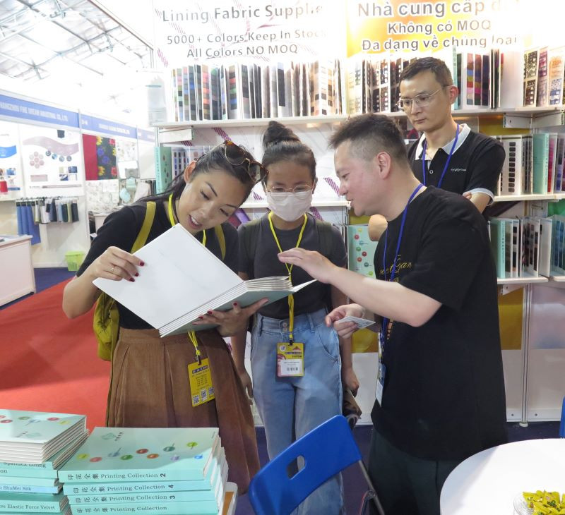 Khách tham quan, tìm hiểu sản phẩm dệt may tại một gian hàng tại triển lãm trong sáng 5/4.