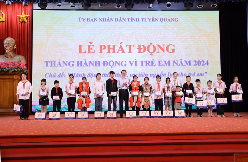 Lãnh đạo tỉnh Tuyên Quang và lãnh đạo Cục Trẻ em, Bộ Lao động-Thương binh và Xã hội trao học bổng cho các em học sinh tại lễ phát động Tháng hành động vì trẻ em năm 2024. (Ảnh: HẢI CHUNG)