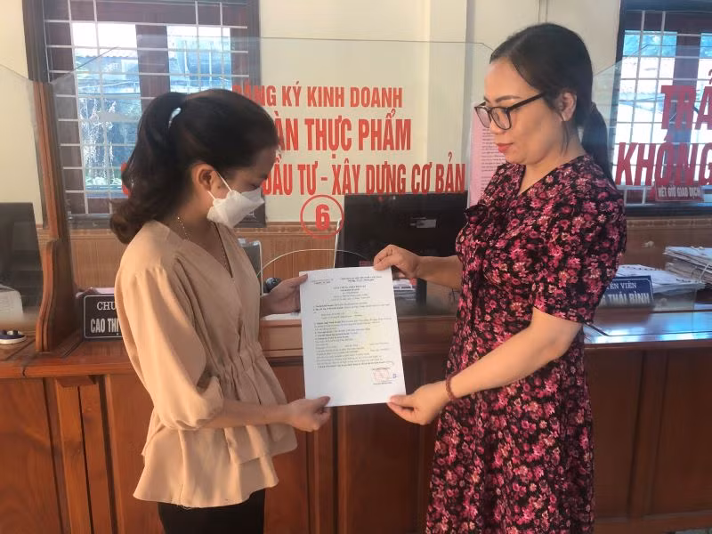 Công chức Bộ phận một cửa huyện Nghi Lộc (Nghệ An) trao Giấy chứng nhận đăng ký hộ kinh doanh cho người dân.