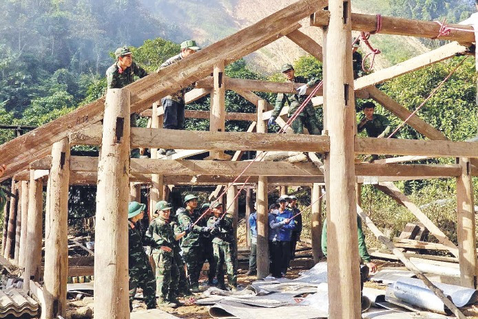 Cán bộ, chiến sĩ Trung đoàn 741 (Bộ Chỉ huy Quân sự tỉnh Điện Biên) giúp nhân dân vùng lũ quét Mường Pồn làm nhà ở.