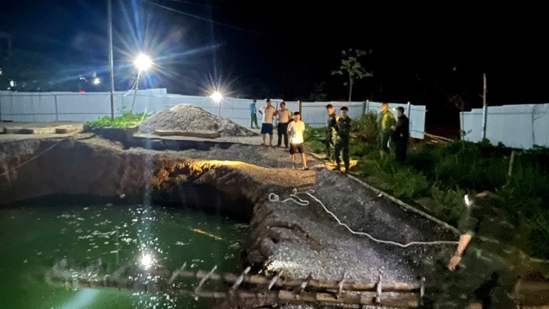 Lực lượng chức năng và người dân tìm kiếm tại khu vực hố sụt trong đêm 26/7. (Ảnh: TUẤN SƠN).