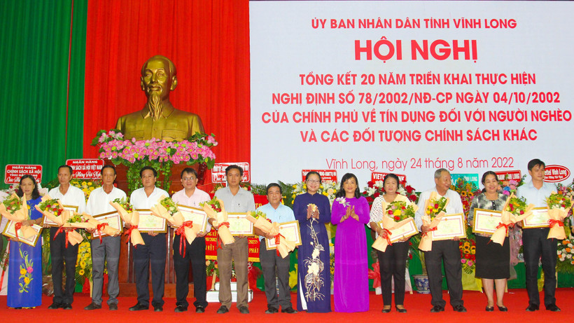 Lãnh đạo UBND tỉnh Vĩnh Long tặng Bằng khen cho những tập thể và cá nhân đã có thành tích trong triển khai, thực hiện vốn vay ưu đãi đối với hộ nghèo và các đối tượng chính sách. (Ảnh: BÁ DŨNG)