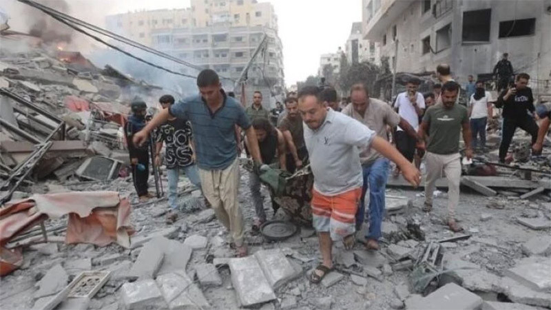 Chuyển thi thể nạn nhân sau các cuộc không kích của Israel xuống Dải Gaza. Ảnh: IRNA/TTXVN