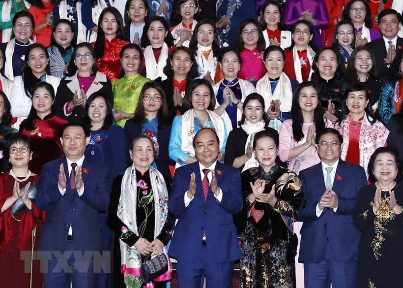 Chủ tịch nước Nguyễn Xuân Phúc, Thủ tướng Chính phủ Phạm Minh Chính, Chủ tịch Quốc hội Vương Đình Huệ, các lãnh đạo, nguyên lãnh đạo Đảng, Nhà nước với các nữ đại biểu. (Ảnh: TTXVN)