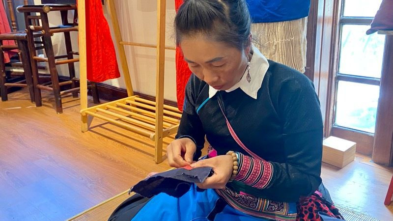 Nghệ nhân Sùng Thị Xé tỉ mỉ thêu ghép vải. 