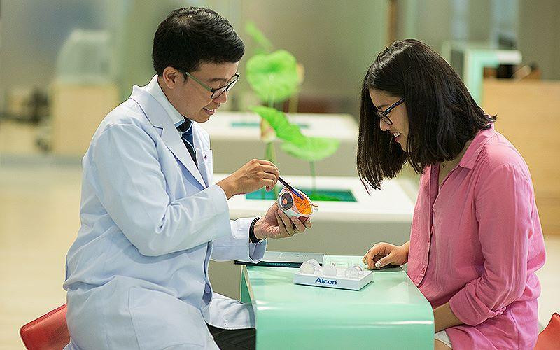 TS, BS Trần Đình Minh Huy (bên trái) chăm sóc, giải đáp thắc mắc của người bệnh. 