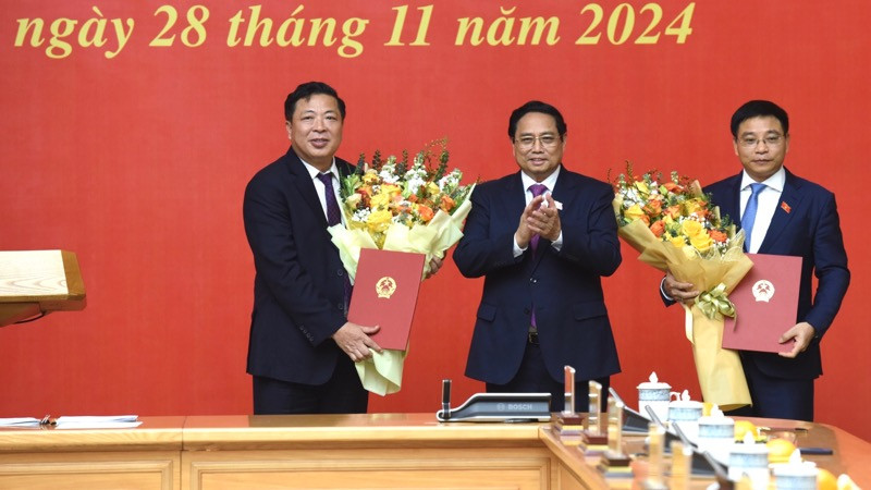 Thủ tướng Phạm Minh Chính tặng hoa chúc mừng Bộ trưởng Tài chính Nguyễn Văn Thắng và Bộ trưởng Giao thông vận tải Trần Hồng Minh. (Ảnh: Trần Hải)