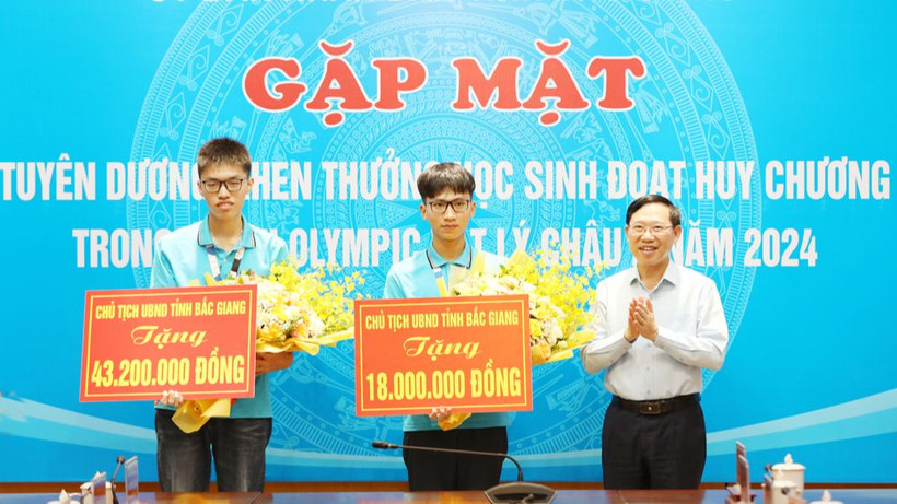 Chủ tịch Ủy ban nhân dân tỉnh Bắc Giang Lê Ánh Dương trao thưởng cho hai học sinh.