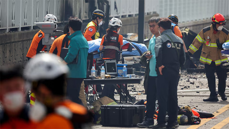 Lực lượng khẩn cấp đưa thi thể nạn nhân ra khỏi hiện trường. (Ảnh: Reuters)