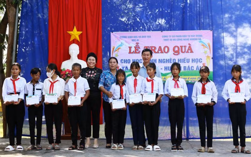 Đại diện nhà tài trợ và lãnh đạo huyện Bác Ái trao quà cho học sinh dân tộc thiểu số Raglai vượt khó học giỏi.