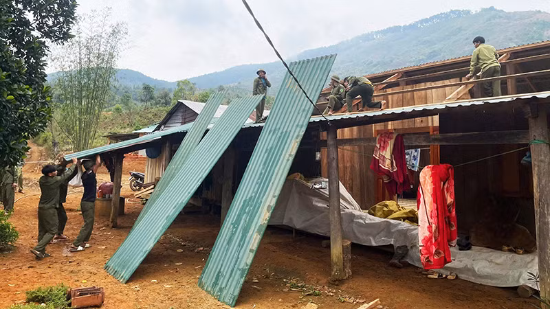 Lực lượng dân quân tự vệ và thanh niên hỗ trợ người dân sửa chữa lại nhà cửa.