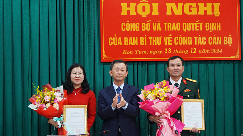 Đồng chí Dương Văn Trang trao Quyết định và tặng hoa 2 đồng chí Trương Thị Linh và Nguyễn Thế Vinh.