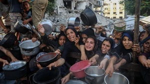 Người dân Palestine di dời khỏi chiến sự chờ nhận thực phẩm miễn phí từ một trung tâm phân phối thực phẩm ở thành phố Gaza, ngày 14/7/2025. (Ảnh: Xinhua)