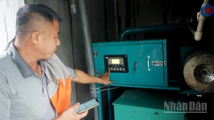 Ông Trần Xuân Phong vận hành máy phát điện từ khí biogas. (Ảnh: TRUNG HƯNG)