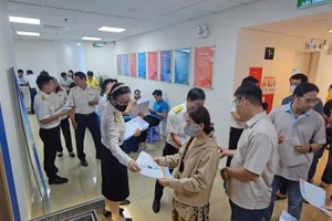 Đại diện Thuế cơ sở 1 Thành phố Hồ Chí Minh phát tài liệu tuyên truyền chính sách thuế đến hộ, cá nhân kinh doanh tại Thành phố Hồ Chí Minh.