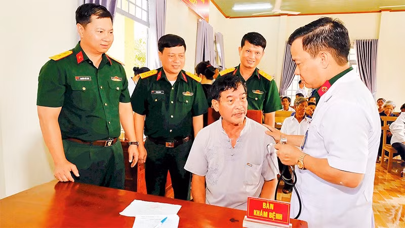 Lãnh đạo Trung đoàn 719 và bác sĩ Bệnh xá Quân dân y thăm hỏi và khám bệnh cho nhân dân.