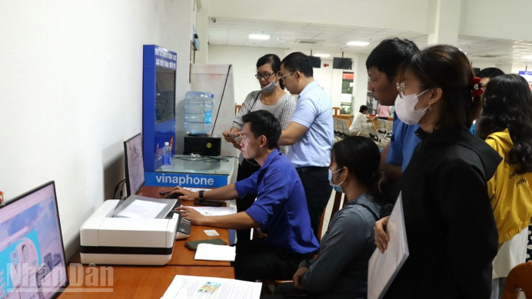 Thanh niên tình nguyện hỗ trợ người dân nộp hồ sơ trực tuyến tại Trung tâm phục vụ hành chính công xã Long Thành, tỉnh Đồng Nai. ndo_bl_img-6721-resize-3859.jpg