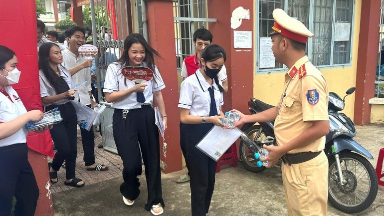 Cảnh sát giao thông Công an tỉnh Đồng Nai phát nước suối cho thí sinh tại Trường trung học phổ thông Điểu Cải, huyện Định Quán. 5-3935.jpg