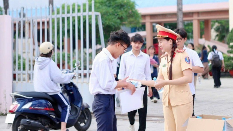 Nữ Cảnh sát giao thông Công an tỉnh Đồng Nai phát nước suối cho thí sinh tại điểm thi Trường trung học phổ thông Ngô Quyền, thành phố Biên Hòa . 1-6313.jpg