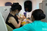 Tiếp viên Vietnam Airlines hỗ trợ chăm sóc sức khỏe hành khách trên một chuyến bay.