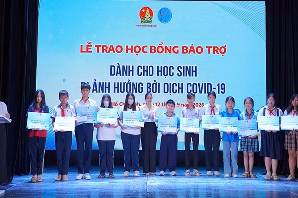 Đại diện Ban tổ chức trao học bổng bảo trợ dành cho các em học sinh bị ảnh hưởng đại dịch Covid-19. (Ảnh: CTV)