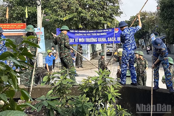 Thanh niên lực lượng vũ trang tham gia dọn vệ sinh, khơi thông dòng chảy rạch Nhà Nuôi. (Ảnh: HOÀNG LIÊM)