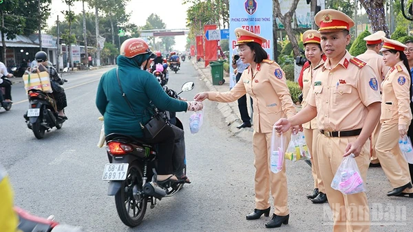 Các lực lượng phát nước suối và khăn lạnh tặng người dân về quê đón Tết.