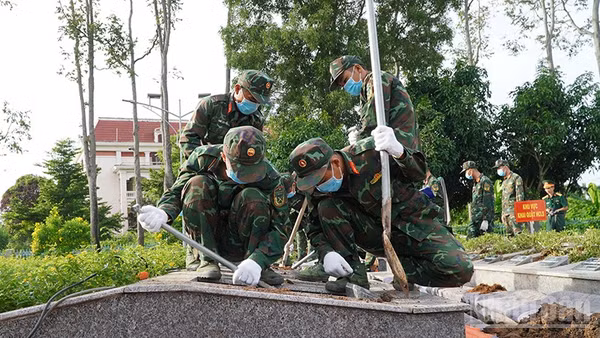 Lực lượng chức năng tiến hành khai quật để lấy mẫu hài cốt liệt sĩ. (Ảnh: HỮU NGHĨA)