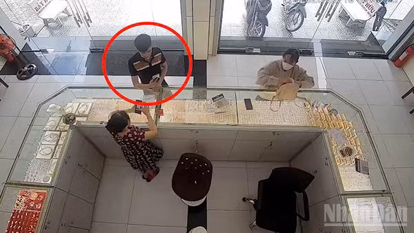 Đối tượng Sang đang thực hiện giao dịch chuyển tiền qua App giả tại cửa hàng kinh doanh vàng (khoanh đỏ).