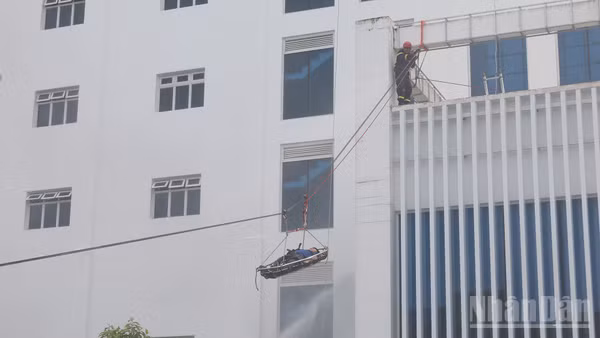 Lực lượng cứu nạn cứu hộ tiếp nhận và đưa người bị nạn xuống đất an toàn trong tình huống giả định xảy ra cháy tại tòa nhà điều hành.