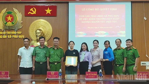 Bà Võ Thị Bình, Chủ tịch Ủy ban nhân dân xã Phú Hựu, tỉnh Đồng Tháp, (đứng thứ 5 từ phải qua trái) trao khen thưởng đột xuất cho em Phạm Nguyễn Anh Thư.