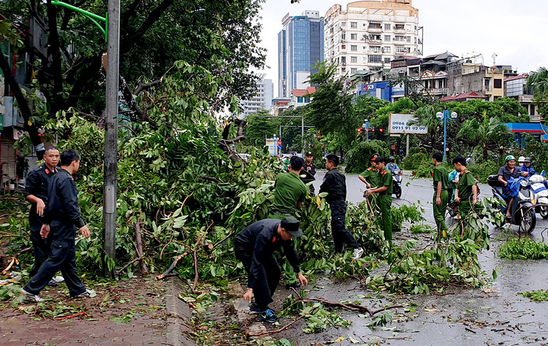 Các chiến sĩ cảnh sát cơ động dọn dẹp cây đổ trên đường Hoàng Quốc Việt.