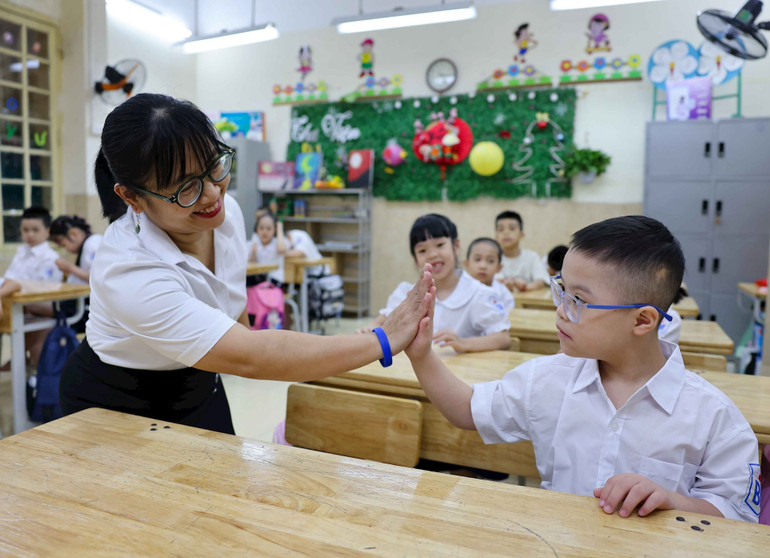 Cô giáo cởi mở, gần gũi trong ngày đầu học sinh đến lớp. Ảnh: TTXVN