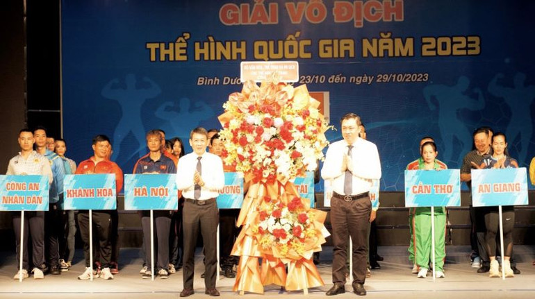 Đại diện Bộ Văn hóa, Thể thao và Du lịch (bên trái) trao hoa cảm ơn địa phương đăng cai giải.