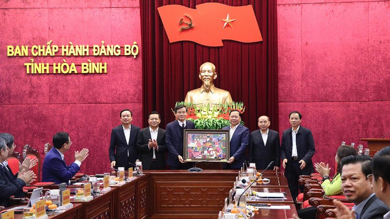 Đồng chí Nguyễn Phi Long, Bí thư Tỉnh ủy Hòa Bình tặng đồng chí Đoàn Minh Huấn, Bí thư Tỉnh ủy Ninh Bình bức tranh mang đậm nét bản sắc văn hóa dân Mường Hòa Bình.