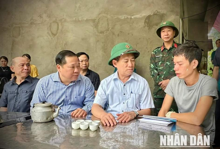 Phó Thủ tướng Hồ Đức Phớc (giữa) thăm hỏi, động viên gia đình có người bị tử vong do mưa lũ gây ra.