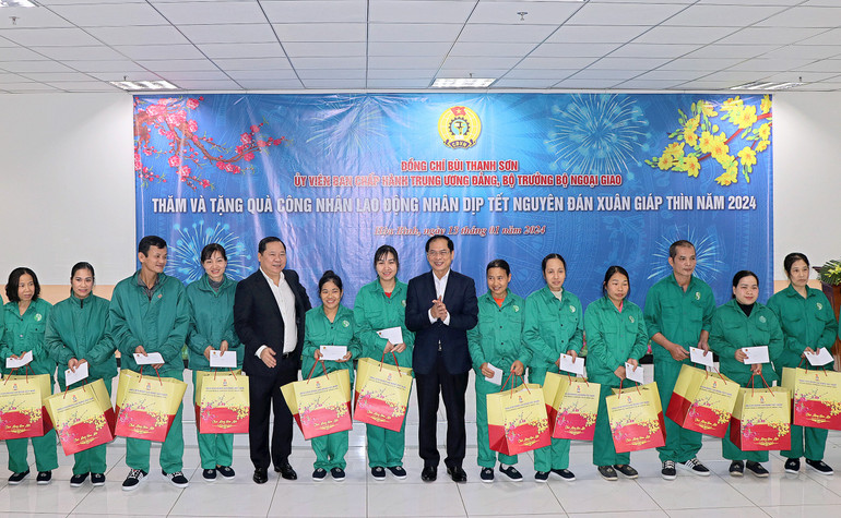Bộ trưởng Ngoại giao Bùi Thanh Sơn (phải) và Bí thư Tỉnh ủy Hòa Bình (trái) tặng quà cho công nhân Khu công nghiệp bờ trái sông Đà nhân dịp Tết Nguyên đán Giáp Thìn.
