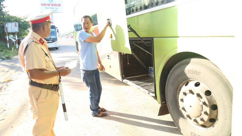 Cảnh sát giao thông đang kiểm tra một xe ô-tô kinh doanh vận tải hành khách. Cảnh sát giao thông đang kiểm tra một xe ô-tô kinh doanh vận tải hành khách.