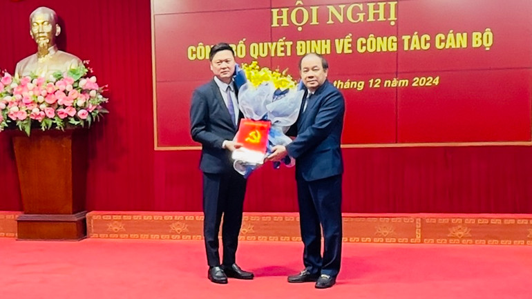 Đồng chí Tạ Văn Long trao quyết định cho Phó Bí thư Huyện ủy Trần Việt Quý. (Ảnh: THANH SƠN)