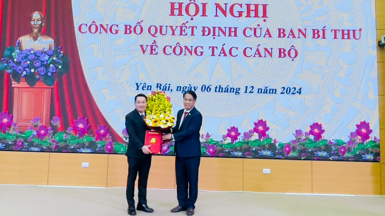 Đại diện Ban Tổ Chức Trung ương trao quyết định và tặng hoa chúc mừng đồng chí Nguyễn Tuấn Anh. (Ảnh: THANH SƠN)