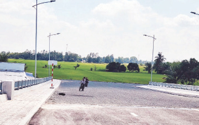 Phía bên kia cầu là ruộng lúa, tương lai sẽ là tuyến đường kết nối thuộc dự án Khu đô thị đông, tây Trung tâm hành chính huyện Giồng Riềng.