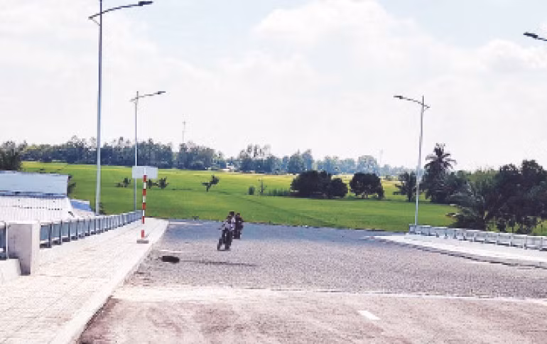 Phía bên kia cầu là ruộng lúa, tương lai sẽ là tuyến đường kết nối thuộc dự án Khu đô thị đông, tây Trung tâm hành chính huyện Giồng Riềng.