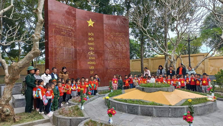 Thắp nến tri ân tại khu mộ tập thể trong quần thể di tích. (Ảnh: THANH SƠN)