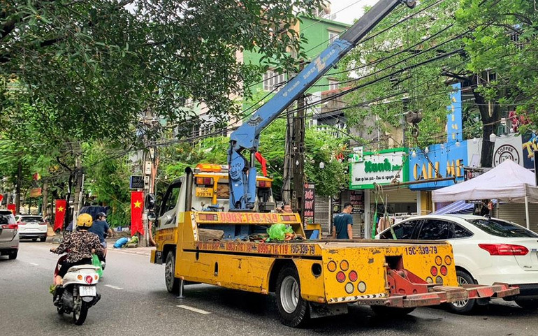 Đến trưa 26/8, xe cứu hộ vẫn tiếp tục giải cứu ô-tô bị chết máy trên đường phố.