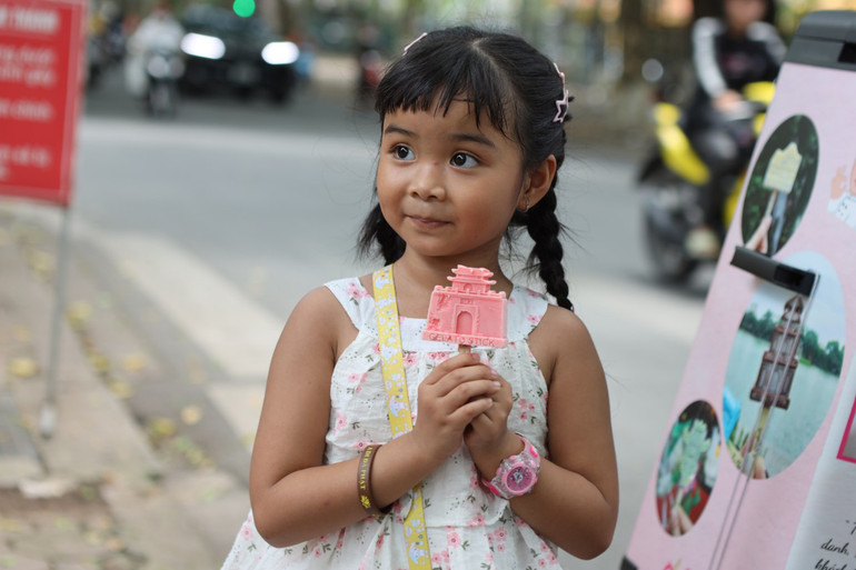 Em nhỏ thích thú với cây kem hình di tích Cửa Bắc.