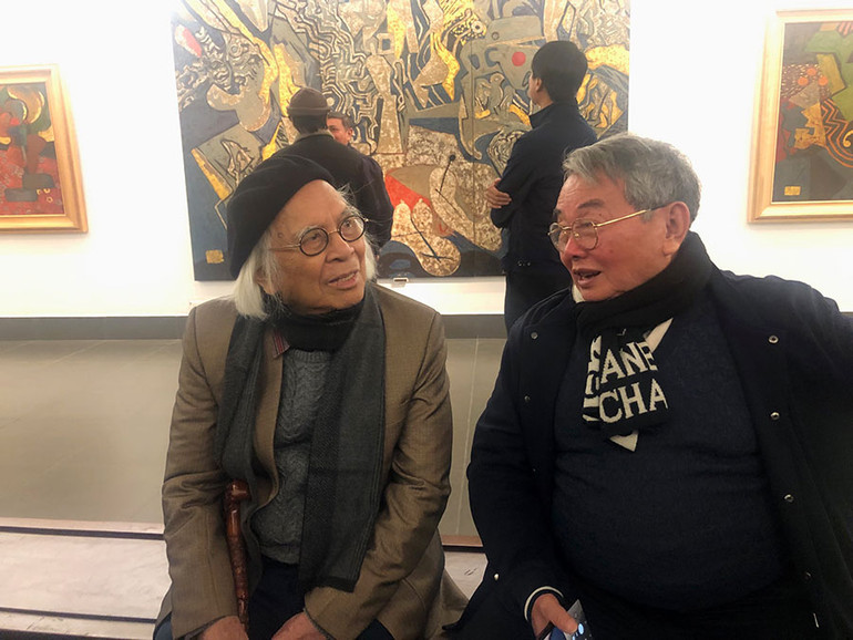 Nhà điêu khắc Tạ Quang Bạo (bên trái) tại triển lãm.