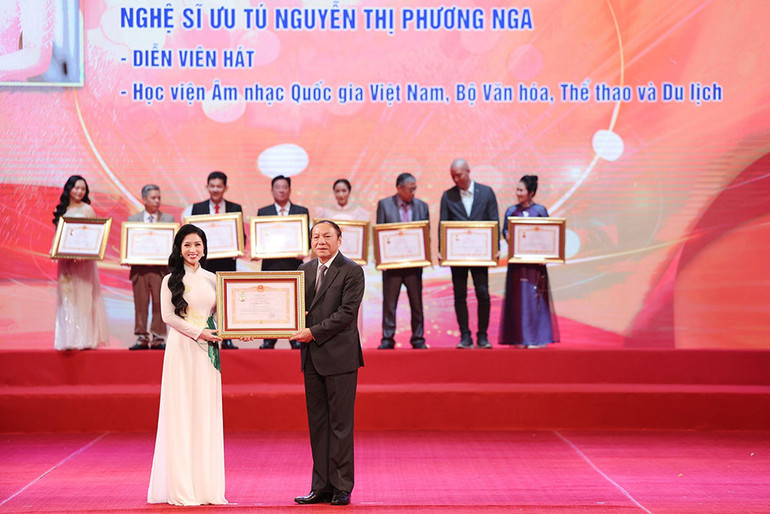 Nghệ sĩ Ưu tú Phương Nga nhận danh hiệu từ Bộ trưởng Văn hóa, Thể thao và Du lịch Nguyễn Mạnh Hùng.